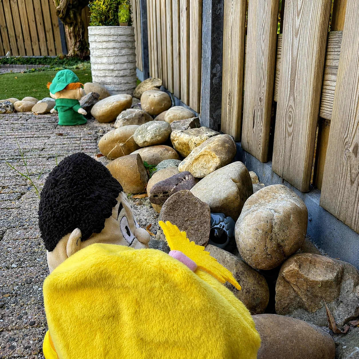 Foto in de tuin van het zoekspel met de handpoppen van de methode.